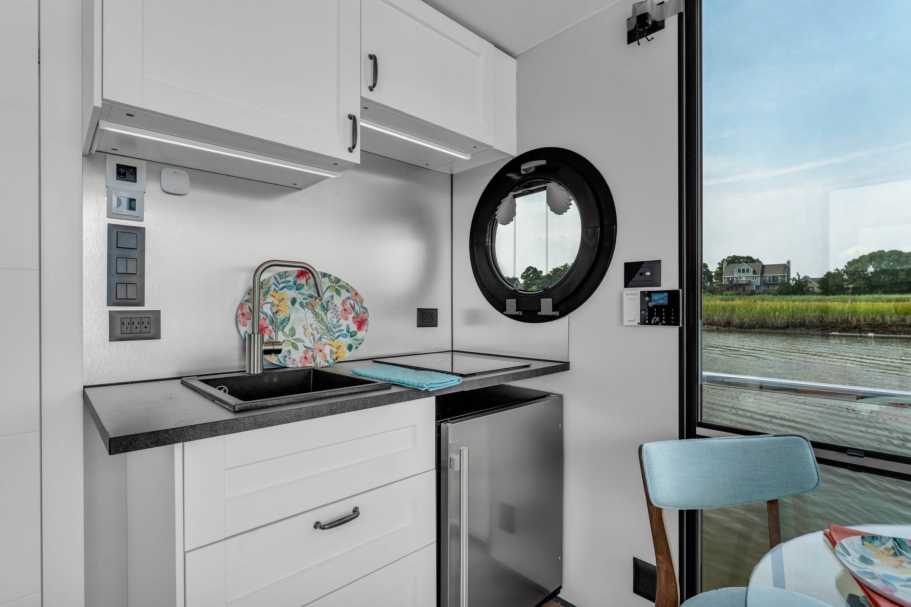 A modern compact kitchen with white walls and a refrigerator.