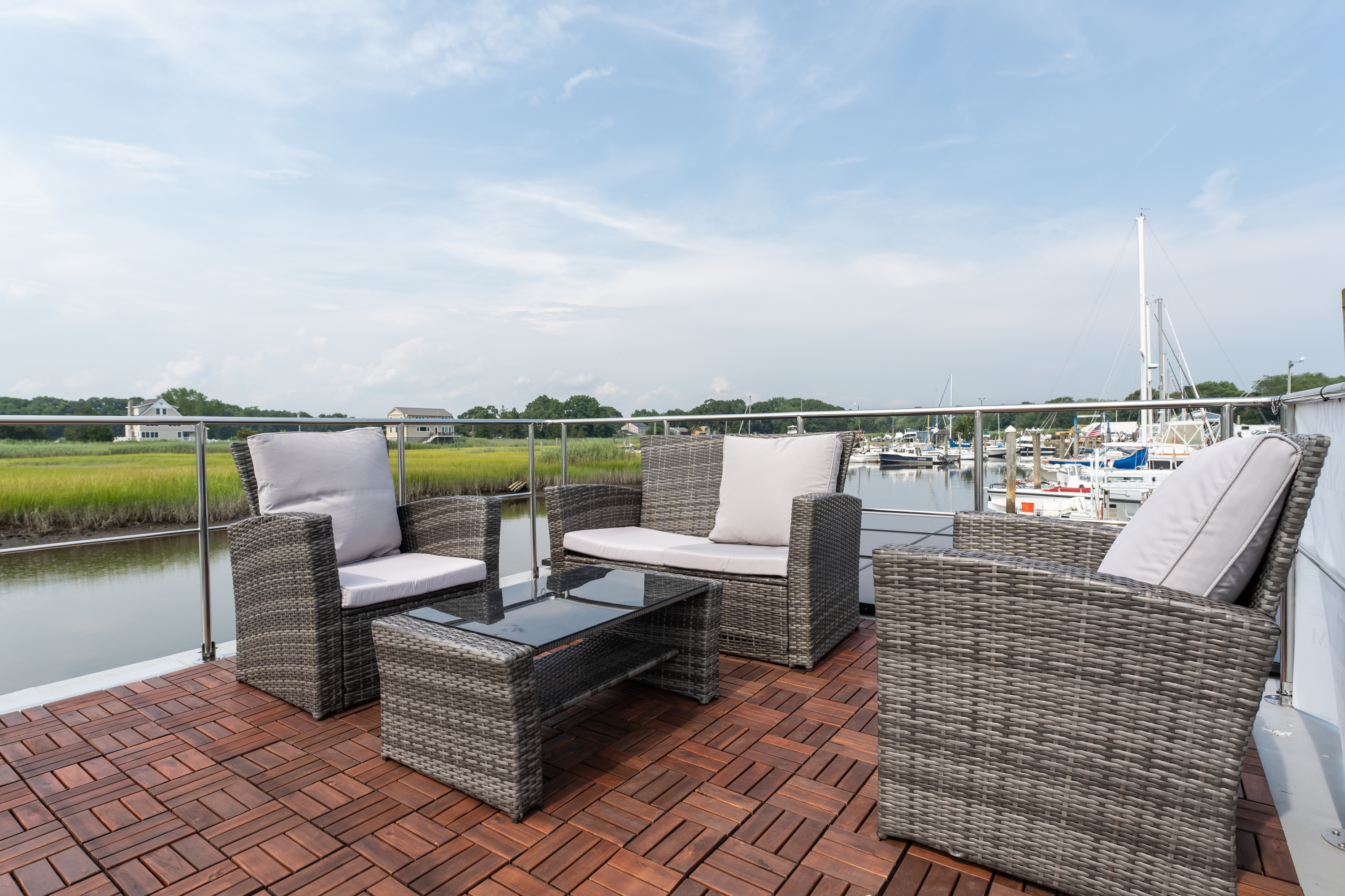 Outdoor patio with chairs overlooking a boat dock under a cloudy sky.