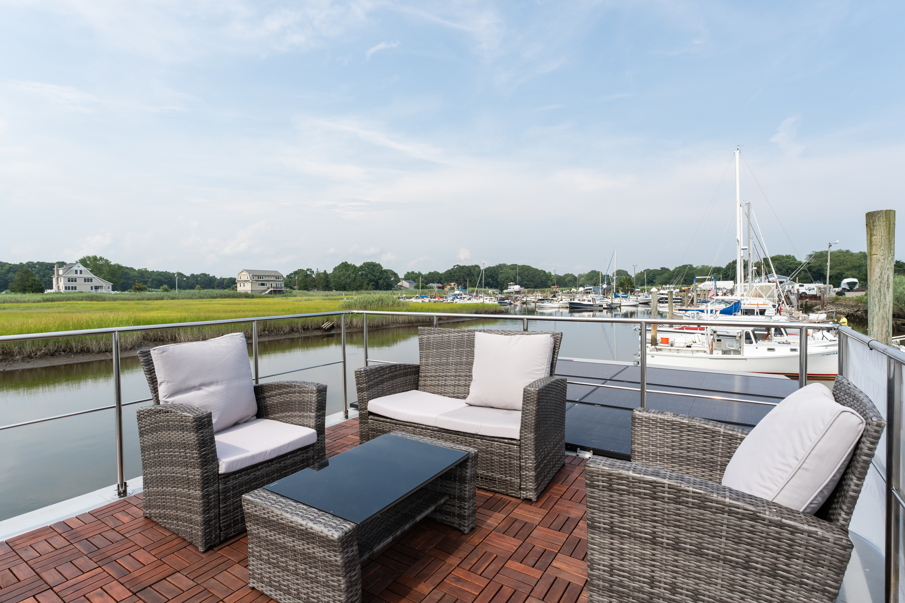 Outdoor patio with chairs overlooking a boat dock under a cloudy sky.